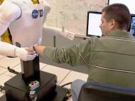 Chris Ihrke, senior project engineer for General Motors, works with Robonaut 2 - new dexterous humanoid robot developed by NASA and General Motors at Johnson Space Center