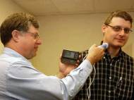 William D. Richard takes an ultrasound probe of colleague David Zar's carotid artery